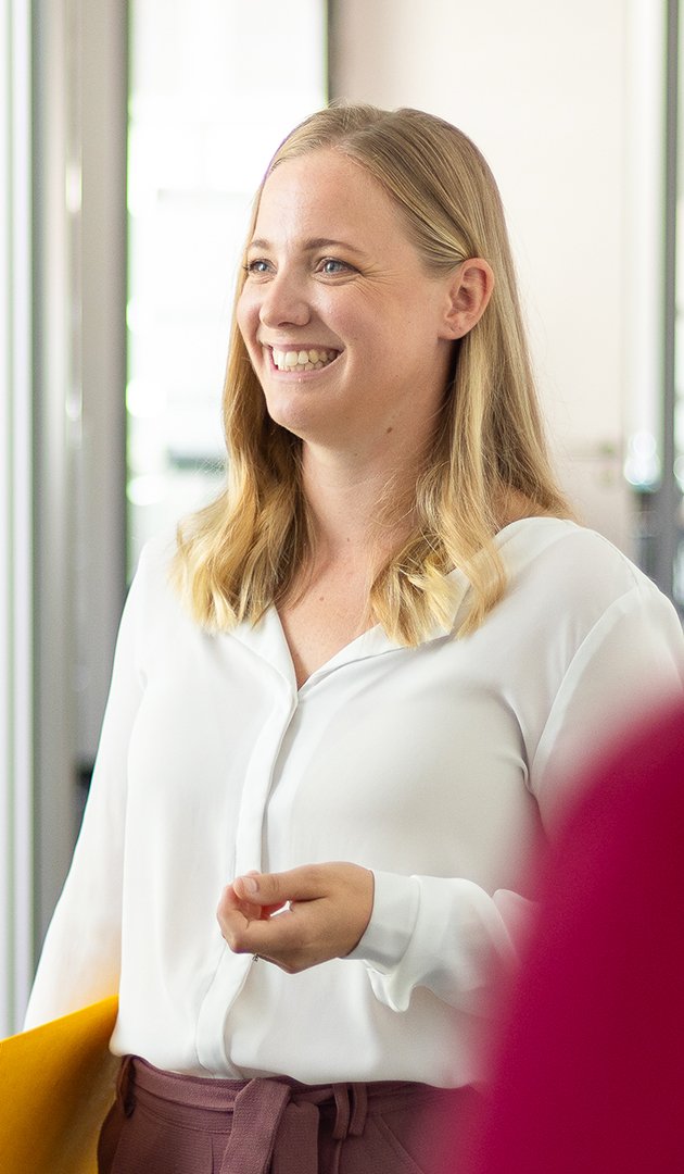 Eine Mitarbeiterin der Insolvenzkanzlei ist im Gespräch und lächelt