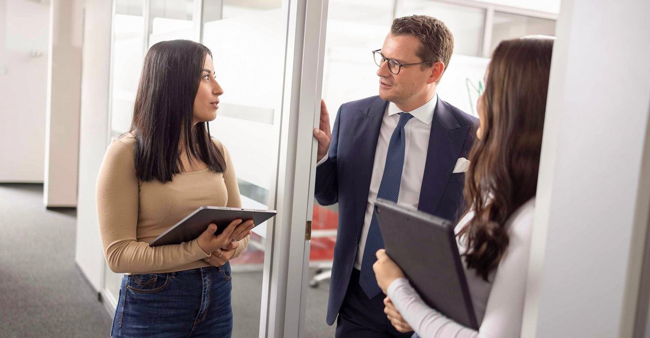 Dr. Malte Köster im Austausch mit zwei Auszubildenden