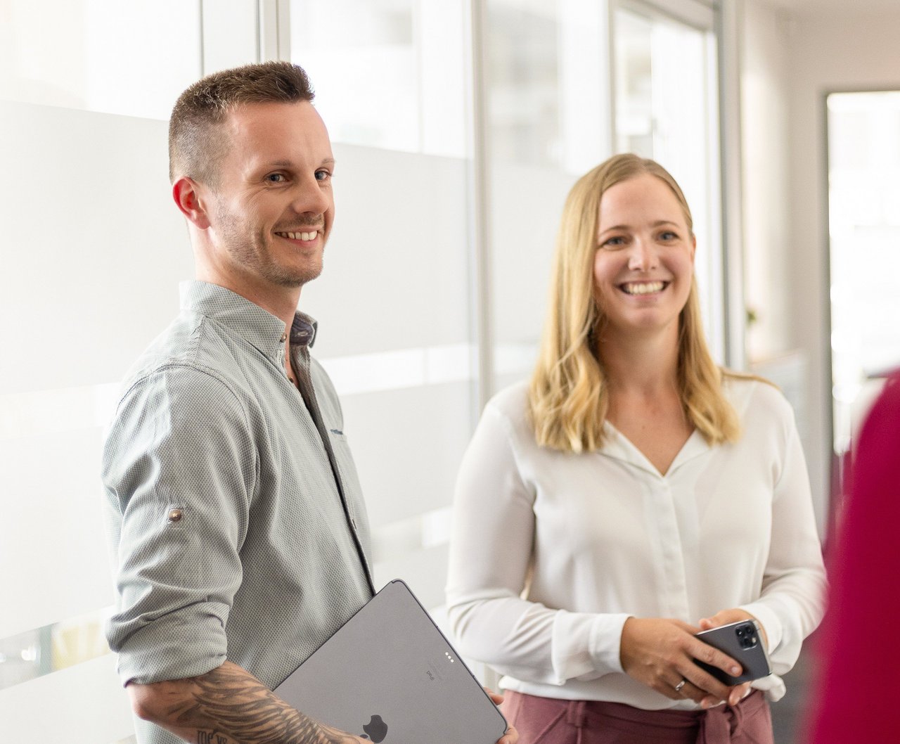 Zwei Mitarbeitende der Insolvenzkanzlei lächeln in die Kamera