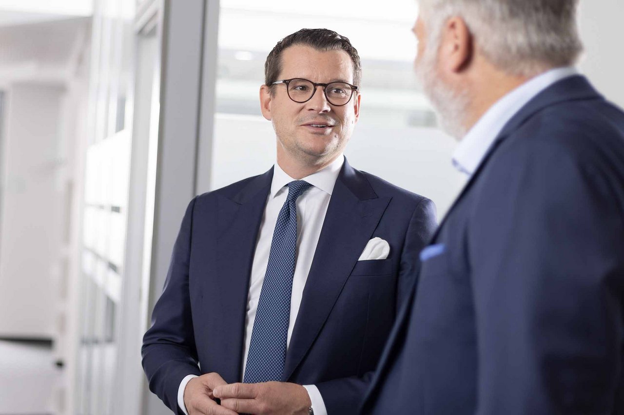 Dr. Malte Koester im freundlichen Gespraech mit Marc Kampfenkel im Flur