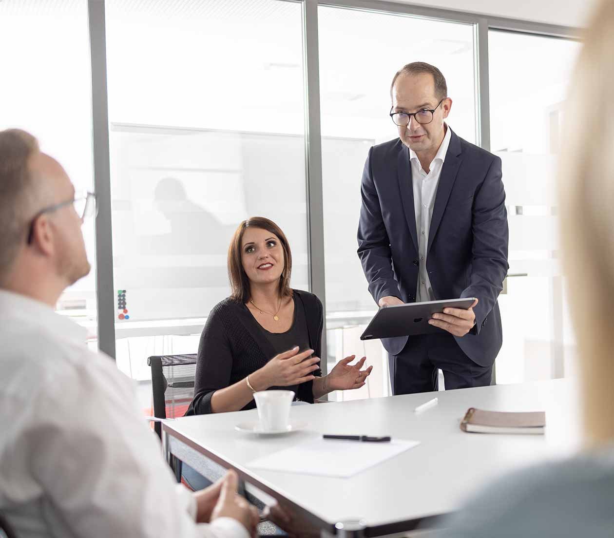 Marc Meyn im Konferenzraum mit konzentriertem Austausch im Team 